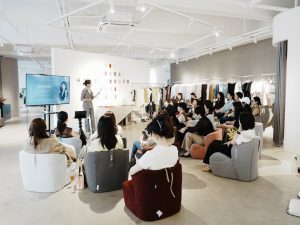 Lu Cai presenting a personal image and styling workshop to an audience in a fashion showroom
